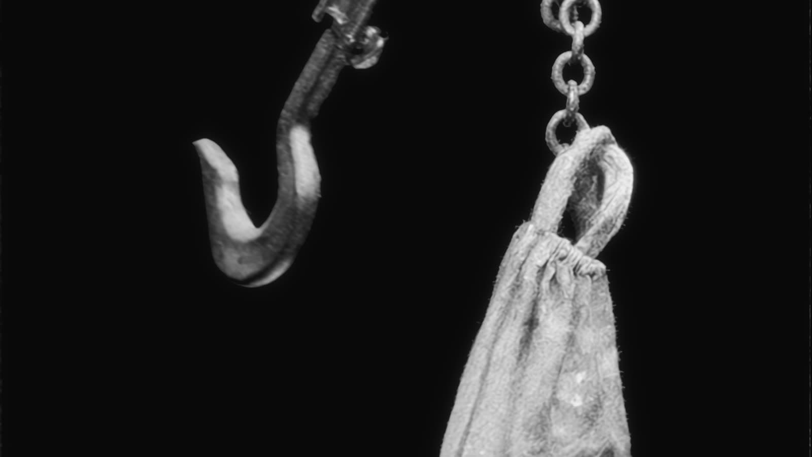 An iron hook and a cloth bag hanging on a chain.